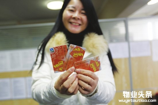 东成大厦业主展示自己收到的超市购物卡
